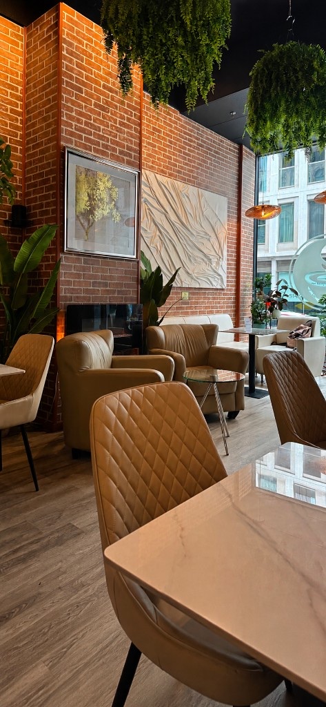 Salon de Cafeterra, fauteuils en cuir, briques et plantes