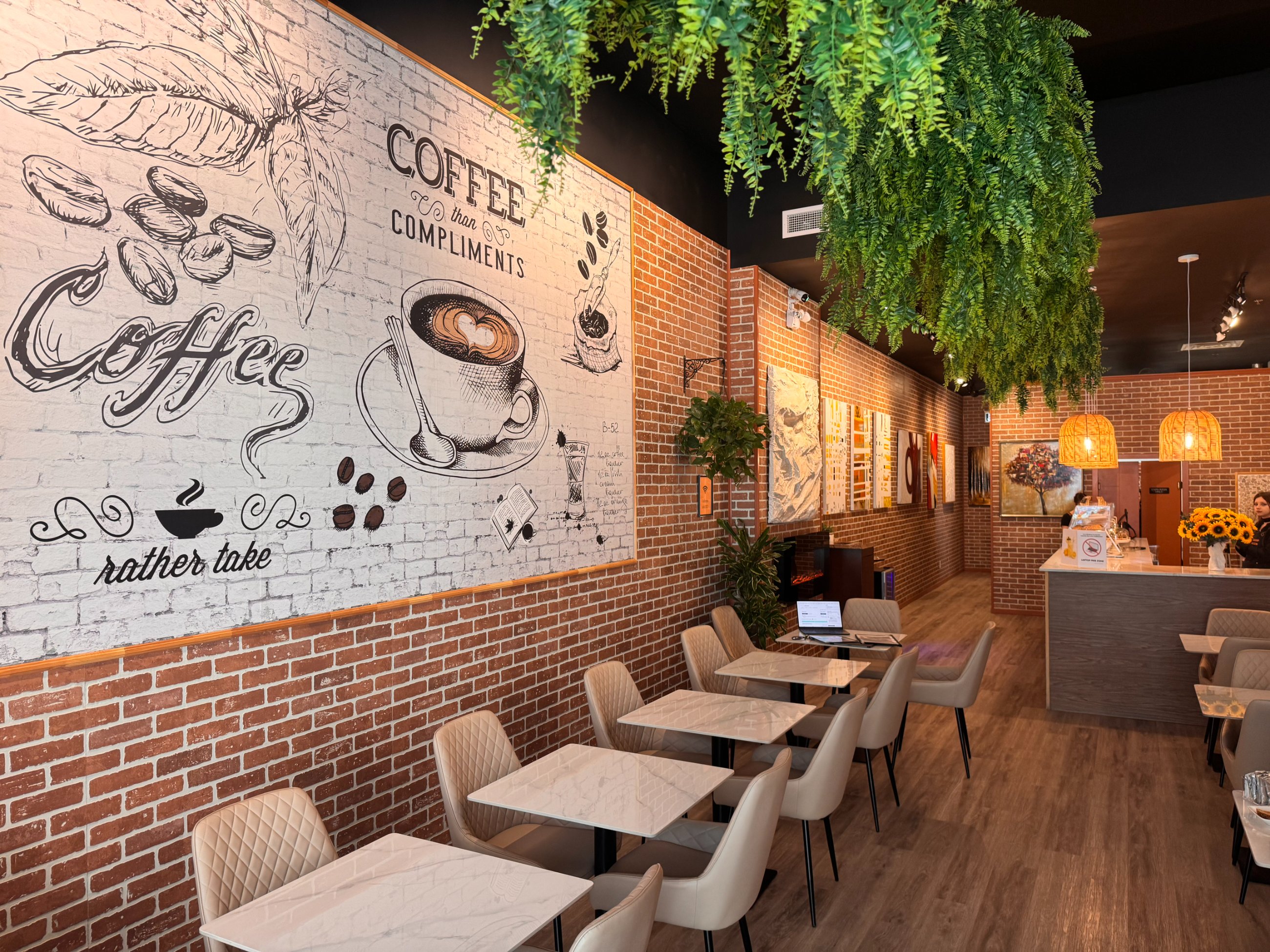 Intérieur de Cafeterra, mur de briques et fresque de café